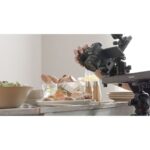 Photographer using Canon camera on tripod for food photography in UK camera shop