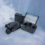 DJI drone with controller and battery pack on icy surface, available at Camix UK.
