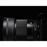 Close-up of a professional camera lens on a black background.