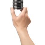 Hand holding a Sigma prime lens, ideal for professional photography.