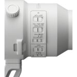 Close-up of a white camera lens with various control switches.