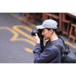 Photographer using a mirrorless camera outdoors in the UK.