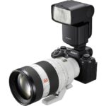 Sony mirrorless camera with telephoto lens and flash, ideal for professional photography.