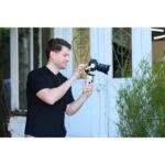 Man using a DSLR camera on a gimbal outside a camera shop in the UK.