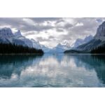 Scenic mountain lake view with cloudy sky and reflections.