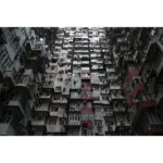 Tall residential building with numerous windows and balconies in an urban setting.