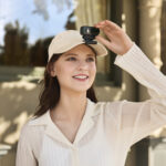 Woman holding a compact camera, ideal for photography enthusiasts.