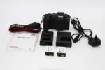 Canon EOS RP camera with accessories including batteries and charger.