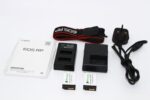 Canon EOS RP camera accessories including batteries, charger, and strap.