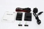 Canon EOS RP camera accessories including batteries, charger, and strap.