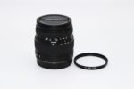 Sigma camera lens with UV filter on white background.