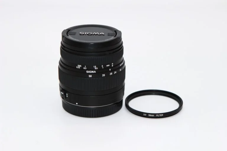 Sigma camera lens with UV filter on white background.