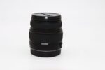 Black camera lens on white background, ideal for photography enthusiasts.