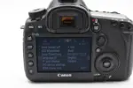 Back view of a Canon DSLR camera displaying settings on the screen.
