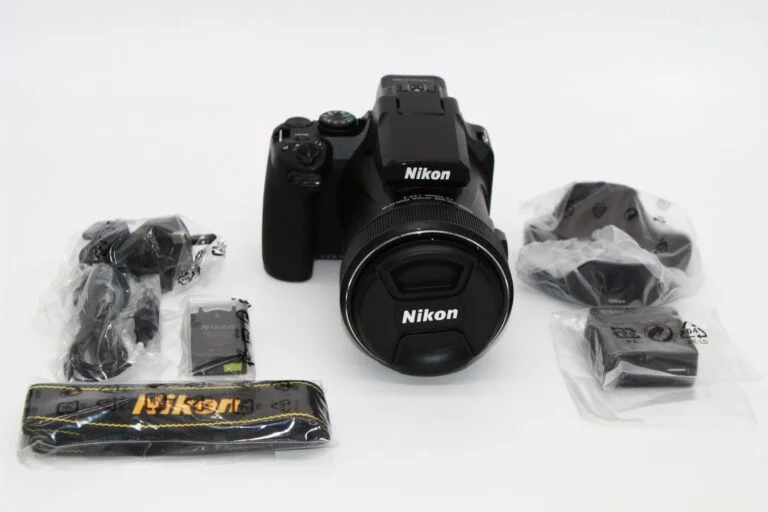 Nikon camera with accessories including strap, lens cap, and cables on display.