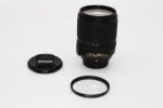 Nikon DX VR lens with cap and UV filter on white background, available at Camix camera shop UK.