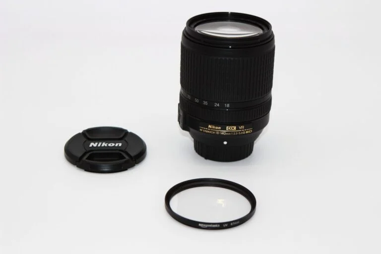 Nikon DX VR lens with cap and UV filter on white background, available at Camix camera shop UK.