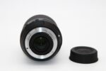 Close-up of a camera lens with cap, ideal for DSLR and mirrorless cameras.
