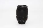 Nikon zoom lens for DSLR cameras on white background.