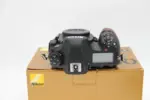 Nikon DSLR camera body on box, top view, available at Camix UK.