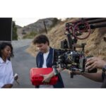 Film crew using professional cinema camera equipment outdoors.