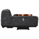 Top view of a mirrorless camera body without a lens, showcasing controls and mount.