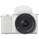 White Sony mirrorless camera with lens and microphone attachment.