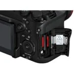 Close-up of a digital camera with dual memory card slots, ideal for professional photographers.