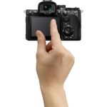 Person using a digital camera with a touchscreen display, available at Camix UK.