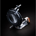 Close-up of a camera lens mount adapter on a black background.