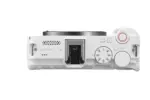 Top view of a white Canon EOS R50 V mirrorless camera body with control dials.