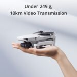 Compact DJI drone in hand, lightweight with 10km video transmission.