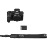 Canon EOS mirrorless camera with battery and strap on white background.